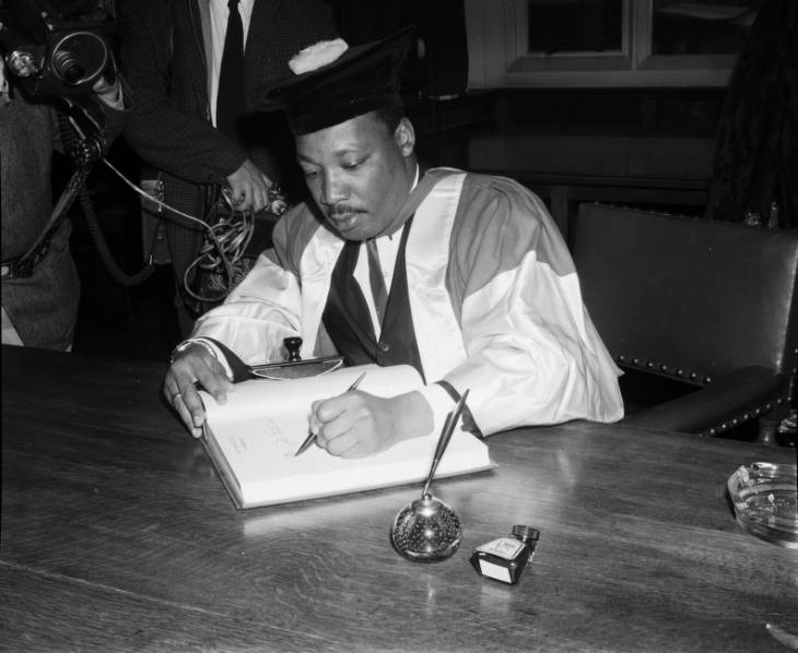 Photograph of Martin Luther signing the guestbook during his visit to Newcastle University to receive an Honorary Degree